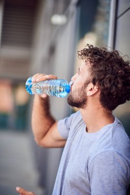 Egzersiz yaptıktan / koştuktan sonra susamış sporcu su içiyor