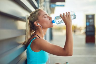Kentsel alanda koştuktan sonra modern sporcu kadın durakladı.