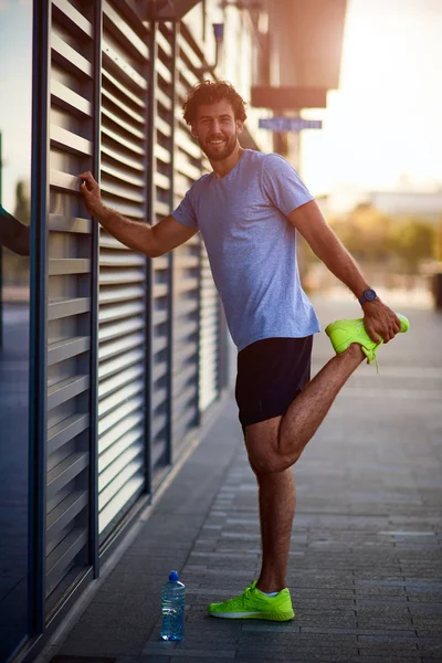 Deportista estirándose en el área urbana durante el jogging / ejercicio . — Foto de Stock