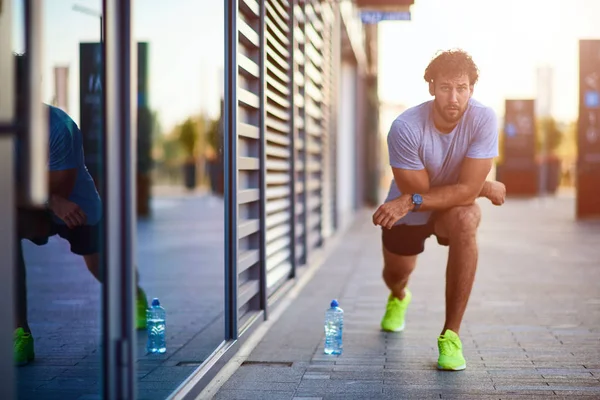Deportista estirándose en el área urbana durante el jogging / ejercicio . — Foto de Stock