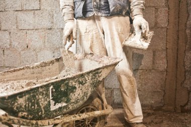 Gerçek inşaat işçisi yeni evin içinde bir duvar yapma.