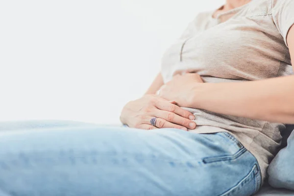 Frau mit Magenproblemen beim Liegen auf der Couch. — Stockfoto