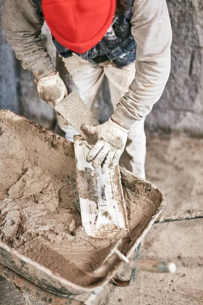 Opravdový stavební pracovník, který dělá v novém domě zeď. — Stock fotografie