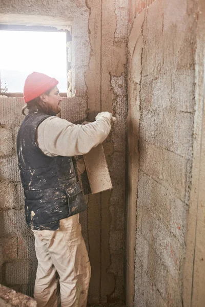 Vrai ouvrier de la construction faisant un mur à l'intérieur de la nouvelle maison . — Photo