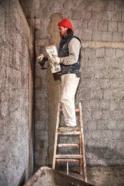 Vrai ouvrier de la construction faisant un mur à l'intérieur de la nouvelle maison . — Photo