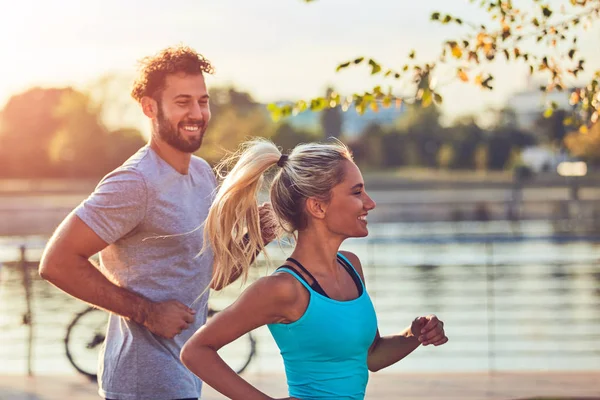 Mujer moderna y hombre trotando / haciendo ejercicio en un entorno urbano — Foto de Stock