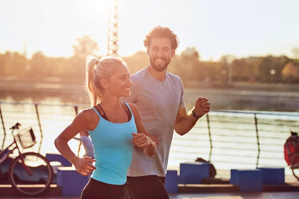 Mujer moderna y hombre trotando / haciendo ejercicio en un entorno urbano — Foto de Stock