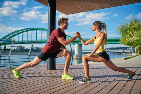 Mujer moderna y el hombre que ejercen en un entorno urbano cerca de la r — Foto de Stock