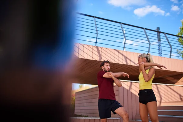 Mujer moderna y el hombre que ejercen en un entorno urbano cerca de la r — Foto de Stock