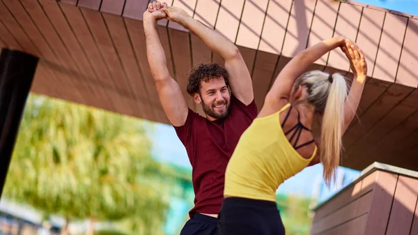 Mujer moderna y el hombre que ejercen en un entorno urbano cerca de la r — Foto de Stock