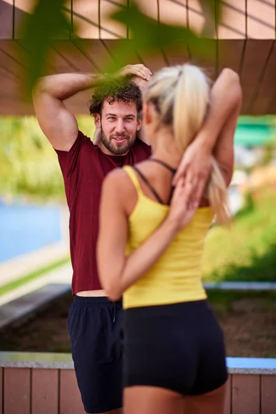 Modern woman and man exercising in urban surroundings near the r — Stock Photo, Image