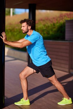 Kentsel çevrede esneyen ve egzersiz yapan bir adam.