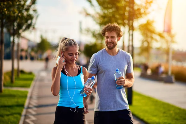 Mujer moderna y hombre trotando / haciendo ejercicio en un entorno urbano — Foto de Stock