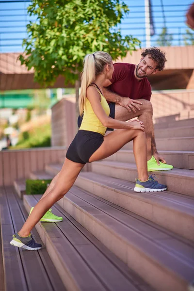 Çağdaş kadın ve erkek şehir çevresinde egzersiz yapıyor.