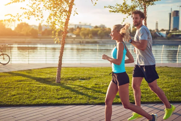 Mujer moderna y hombre trotando / haciendo ejercicio en un entorno urbano — Foto de Stock