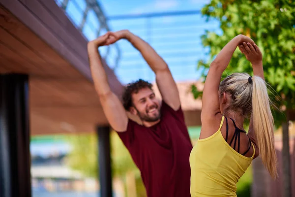 Mujer moderna y el hombre que ejercen en un entorno urbano cerca de la r — Foto de Stock