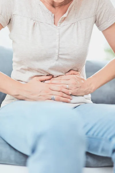 Frau mit Magenproblemen beim Liegen auf der Couch. — Stockfoto