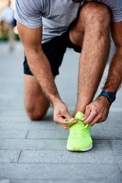 Hombre atando zapatillas en la calle . — Foto de Stock