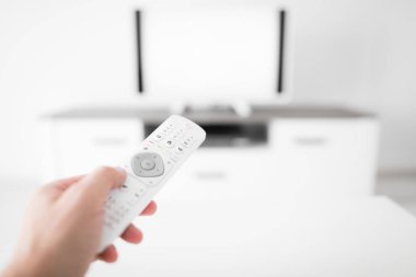Modern bir televizyonla el ele tutuşan uzaktan kumanda..