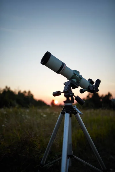 Telescope for observing the universe on a meadow outdoors.