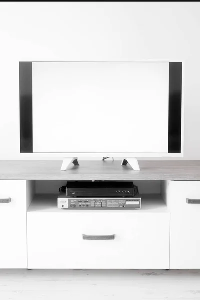 Telewizor z białym ekranem na stojaku w pokoju. — Zdjęcie stockowe