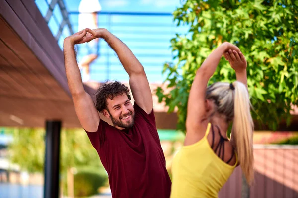 Mujer moderna y el hombre que ejercen en un entorno urbano cerca de la r — Foto de Stock