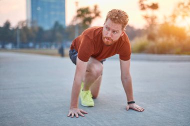 Genç modern adam şehir parkında koşuyor / egzersiz yapıyor.