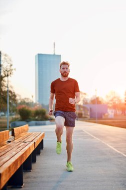 Modern genç adam şehir parkında çalışıyor..