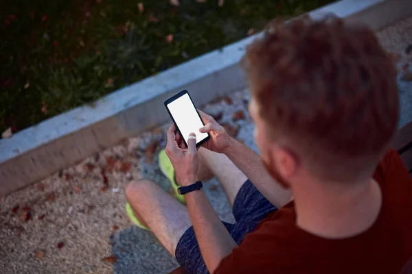 Hombre usando celular en parque urbano por la noche . — Foto de Stock