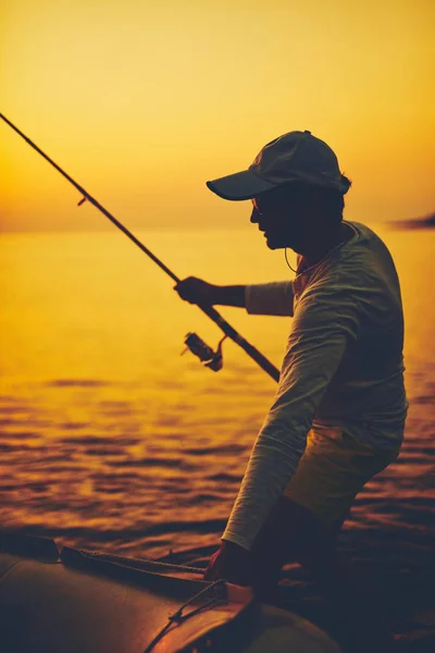 Σιλουέτα ψαρά που ψαρεύει στο ηλιοβασίλεμα στην ανοιχτή θάλασσα — Φωτογραφία Αρχείου