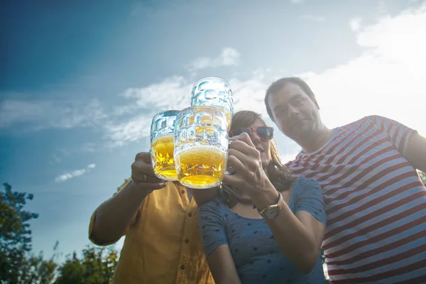 Grupo de jóvenes disfrutando y animando la cerveza al aire libre . — Foto de Stock