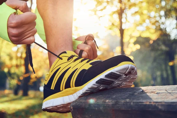 Preparing for jogging in autumn colored park. — Stock Photo, Image