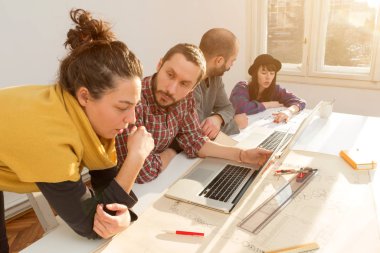 Team made of young architects in the sunny office.