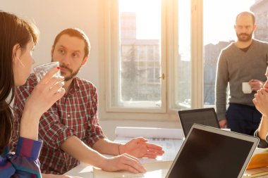 Team made of young architects in the sunny office.