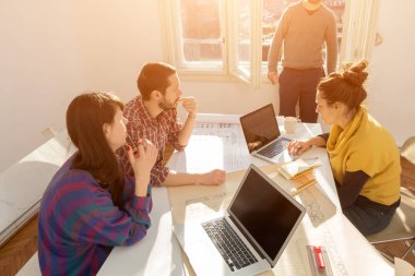 Team made of young architects in the sunny office.
