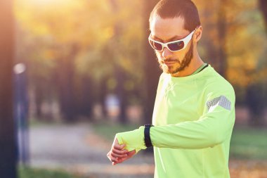 Parkta koşuya / egzersize hazırlanan adam.