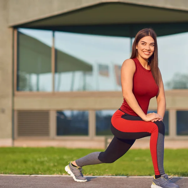 Ung kvinna som tränar / stretchar i stadspark. — Stockfoto