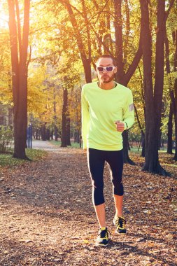 Parkta koşan ve egzersiz yapan bir adam..