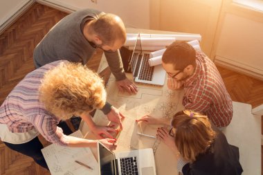 Team made of young architects in the sunny office.