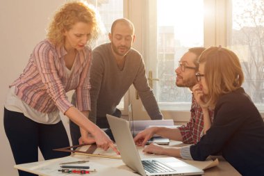 Team made of young architects in the sunny office.