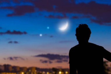 Man looking at the night sky from urban area. clipart