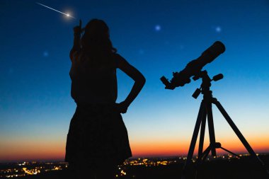 Teleskopla gökbilimci yıldızları ve Ay 'ı izliyor. 