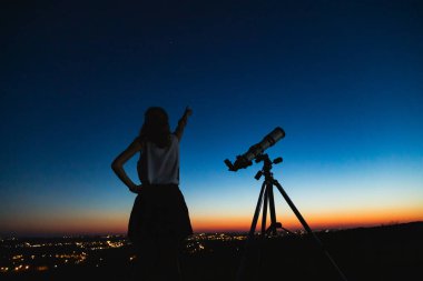 Teleskopla gökbilimci yıldızları ve Ay 'ı izliyor. 