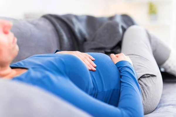 Zwanger vermoeide vermoeide vrouw met maagproblemen thuis op een — Stockfoto