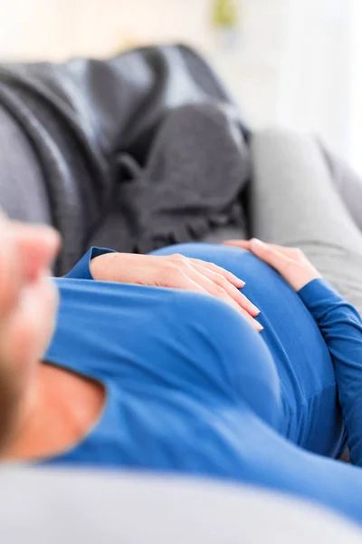Schwangere müde erschöpfte Frau mit Magenproblemen zu Hause auf einem — Stockfoto