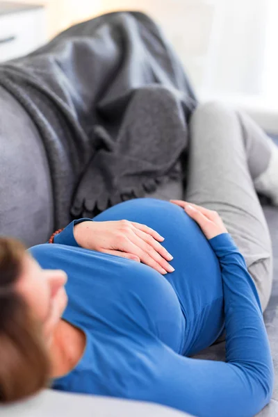 Pregnant tired exhausted woman with stomach issues at home on a — Stock Photo, Image