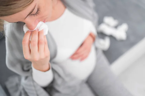 Mujer embarazada contraer resfriado, gripe, virus, sentado en casa en una c —  Fotos de Stock