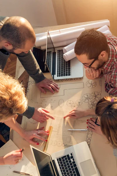 Equipo formado por jóvenes arquitectos en la soleada oficina . — Foto de Stock