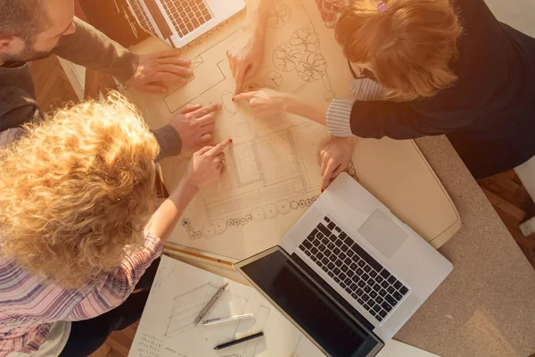 Equipo formado por jóvenes arquitectos en la soleada oficina . — Foto de Stock