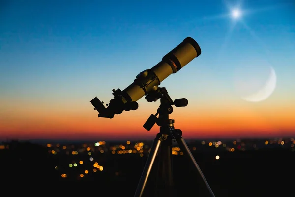 Teleszkóp sziluett és éjszakai égbolt városi fényekkel a háttérben — Stock Fotó